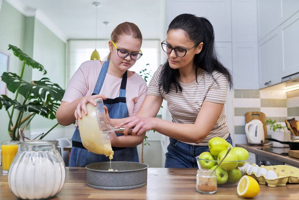 Mom and teenage daughter preparing apple pie together - Foto, Imagem