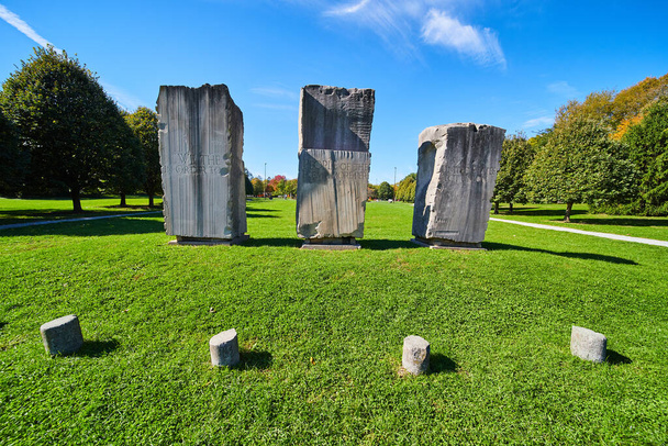 Three large stone obelisks in open green field - Photo, Image