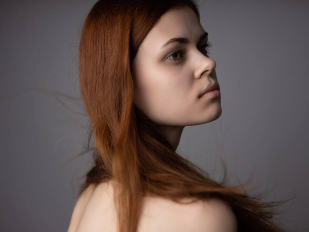 roodharige vrouw kale schouders heldere huid poseren studio - Foto, afbeelding