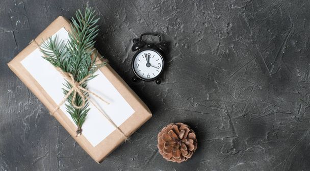 Hediyelerin asgari Noel paketi. Kağıt hazır dekor. Gri arka planda doğal köknar ağacı süslemesi olan ekolojik hediyeler - Fotoğraf, Görsel