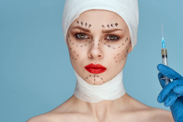 portrait of a woman posing in blue gloves red lips surgery facial rejuvenation close-up - Foto, afbeelding