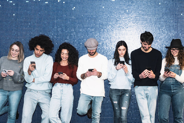 Młodzi ludzie korzystający z mobilnego smartfona na stacji metra - Młodzież tysiącletnia uzależniona od nowej koncepcji technologii - Zdjęcie, obraz