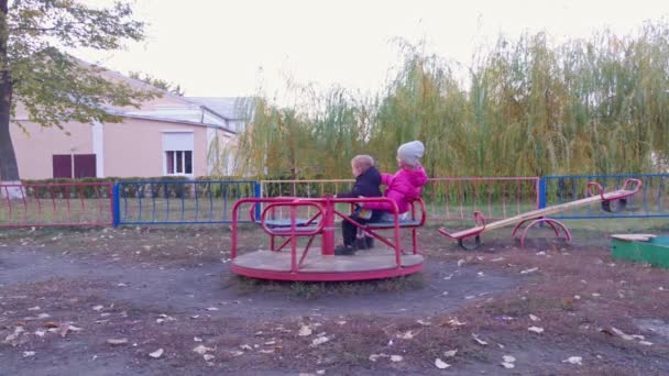Ευτυχισμένο κορίτσι και αγόρι στο καρουζέλ - Πλάνα, βίντεο