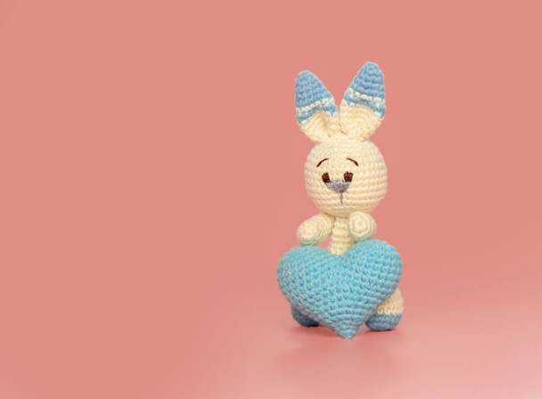 roztomilý králíček se srdcem ve tvaru hračky přes růžové pozadí, přátelství, láska nebo péče koncept, Valentines den karty šablony - Fotografie, Obrázek