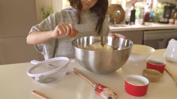 девочка готовит смесь для торта в кружке, десерт выпечки, приготовление пищи с детьми на дому - Кадры, видео
