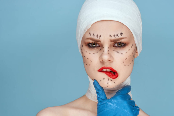 beautiful woman posing in blue gloves red lips surgery facial rejuvenation isolated background - Foto, Bild