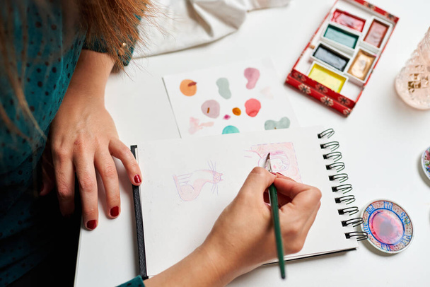 Ilustrador mujer pinta algunos bocetos con acuarelas - Foto, imagen
