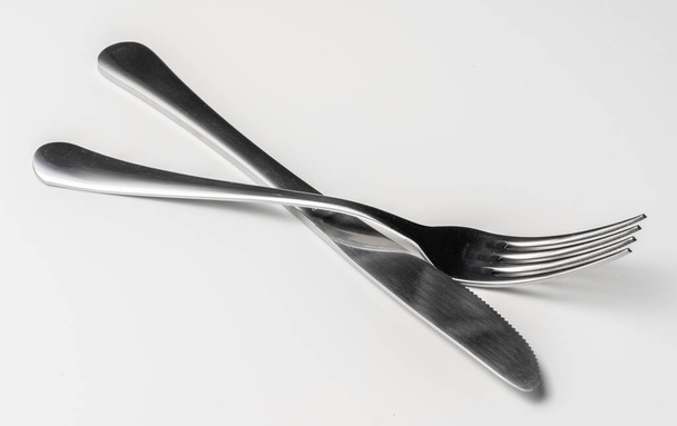 Fork and knife isolated on white background - 写真・画像