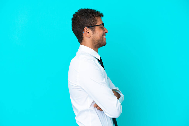 Fiatal üzlet Brazil férfi elszigetelt kék háttér oldalsó pozícióban - Fotó, kép