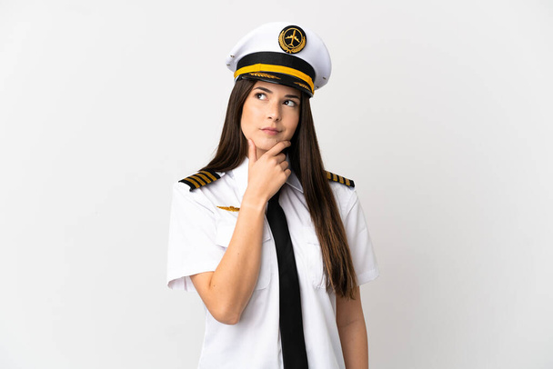 Brazylijka dziewczyna Samolot pilot nad odizolowanym białym tle mając wątpliwości i mylić wyraz twarzy - Zdjęcie, obraz