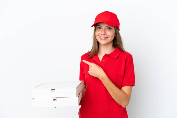 Livraison de pizza femme lituanienne isolée sur fond blanc pointant du doigt sur le côté - Photo, image