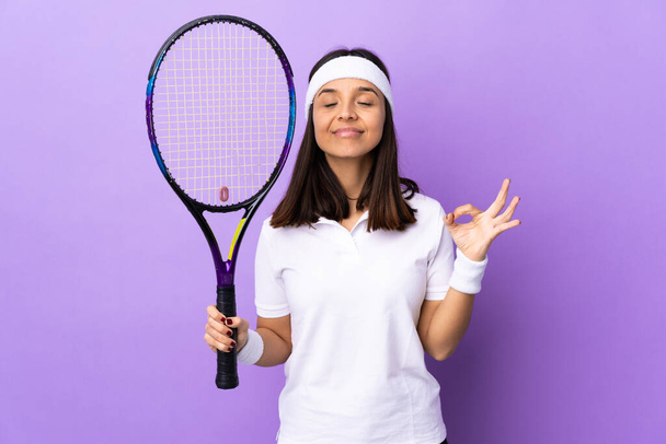 Junge Tennisspielerin mit isoliertem Hintergrund in Zen-Pose - Foto, Bild