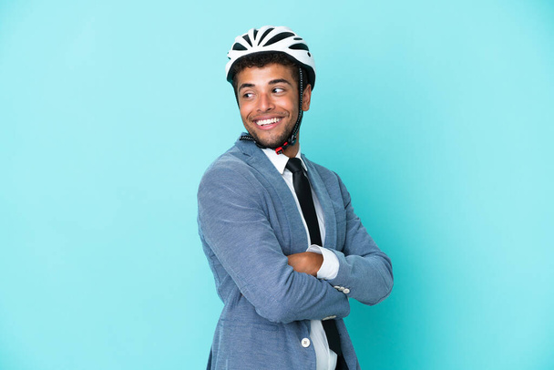 Молодий бізнесмен з бразильського шолома, ізольований на синьому фоні з перехрещеними руками і щасливим. - Фото, зображення