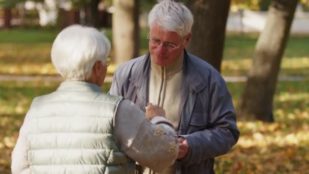Evento de caridad. Anciana, voluntaria dando comida caliente a un anciano - Imágenes, Vídeo
