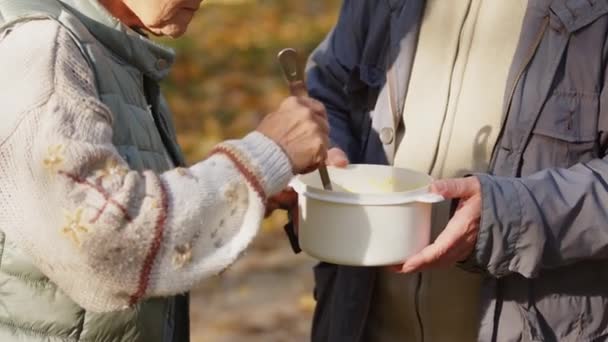 Evento de caridad. Personas mayores recibiendo una comida caliente - Imágenes, Vídeo