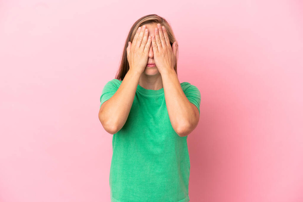 Nuori Englanti nainen eristetty vaaleanpunainen tausta kattaa silmät käsin - Valokuva, kuva
