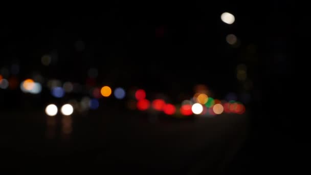Ночью на темном размытом фоне скользит боке. Круглый красочный боке сияет от автомобильных огней на городской улице. Не в фокусе с расплывчатым. Несфокусированные огни города. Пробки на дорогах. Абстрагируясь - Кадры, видео