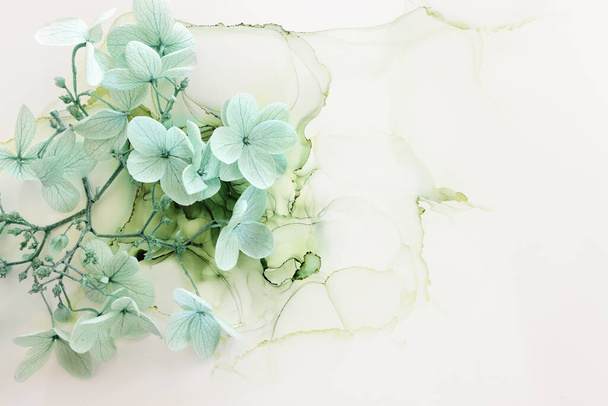 Creative image of pastel mint green Hydrangea flowers on artistic ink background. Top view with copy space - Photo, Image