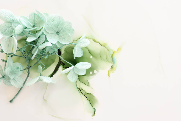 Creative image of pastel mint green Hydrangea flowers on artistic ink background. Top view with copy space - Fotó, kép