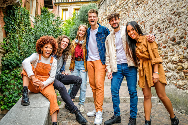 Wieloetniczna grupa młodych ludzi rozmawiających i bawiących się na schodach na ulicach miasta i - Koncepcja miejskiej i przyjaźni - Zdjęcie, obraz