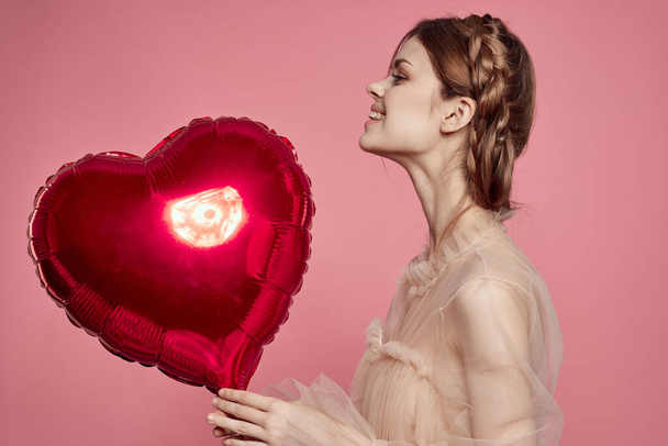 cheerful woman red heart in the hands of the balloon isolated background - Foto, Bild