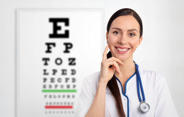 Eye doctor, oculist in clinic. Snellen chart in background - Photo, image