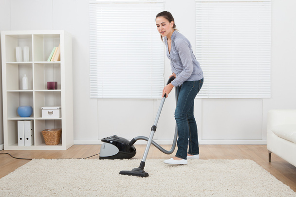 Woman Vacuuming Rug - Foto, afbeelding