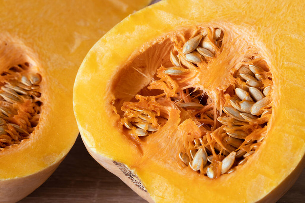orange pumpkin with seeds cut in half close-up - Φωτογραφία, εικόνα