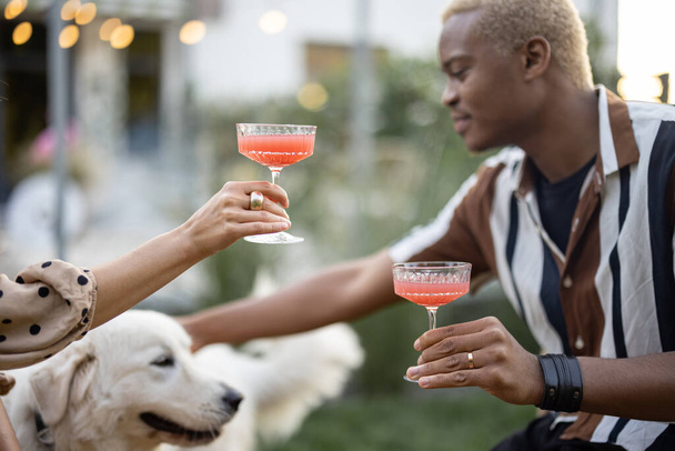 Couple with dog at home party in garden - Фото, изображение