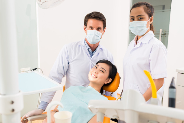 tandarts, assistent en lachende patiënt - Foto, afbeelding