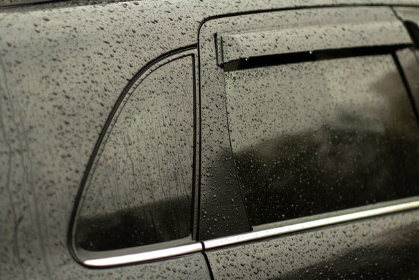 Wet car glass. Drops on transport. Black car in the rain. Machine parts. - Fotoğraf, Görsel
