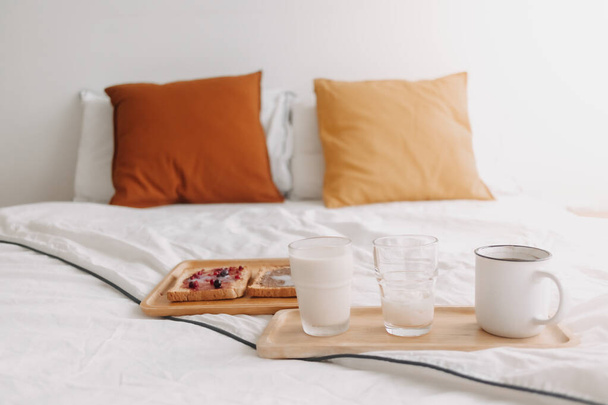 Breakfast set of breads and jam with milk and coffee on white bed. - Photo, image