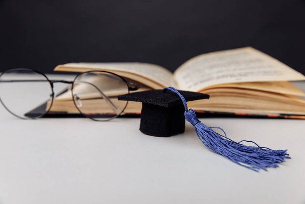 Mütze und Brille mit aufgeschlagenem Buch - Foto, Bild