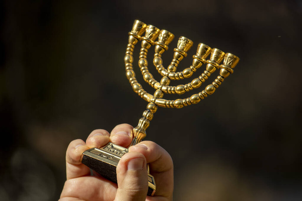 Jewish gilded seven-candlestick in hands - Foto, imagen