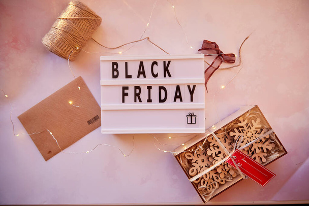 Signboard with text Black Friday and decorations. Online shopping concept. Buying presents for Christmas. Safe home shopping. Cozy home. Christmas preparations.Top view. High quality photo - Фото, изображение