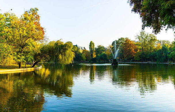 ブカレスト市内中心部の公園、シミギウガーデン(グラディナシミギウ)の湖の近くに鮮やかな緑の風景 - 写真・画像