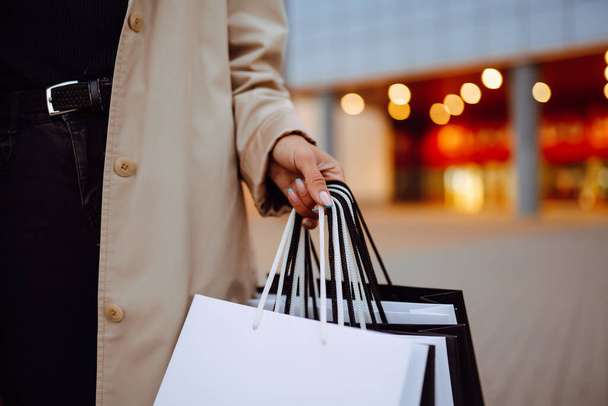 Shopping bags in the woman hands. Black friday. Consumerism, purchases, sale, lifestyle,  tourism and happy people concept. - Photo, image