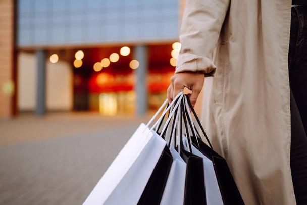 Shopping bags in the woman hands. Black friday. Consumerism, purchases, sale, lifestyle,  tourism and happy people concept. - Φωτογραφία, εικόνα
