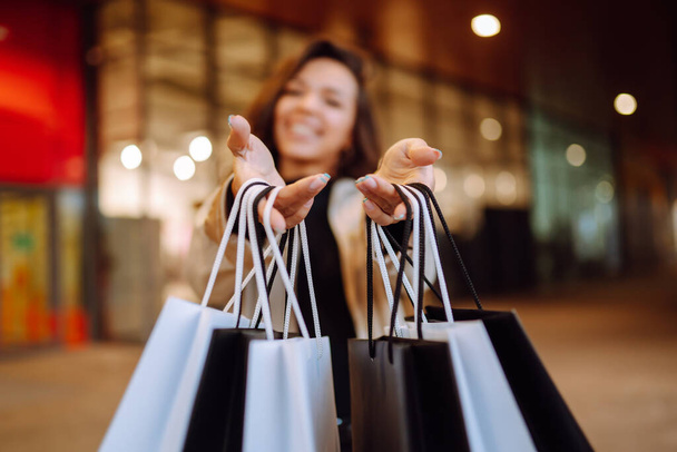 Shopping bags in the woman hands. Black friday. Consumerism, purchases, sale, lifestyle,  tourism and happy people concept. - Foto, Imagen