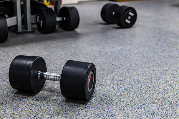 nehéz súlyzók az erőnléti edzéshez a földön vannak. a padlón fekvő súlyzók - Fotó, kép