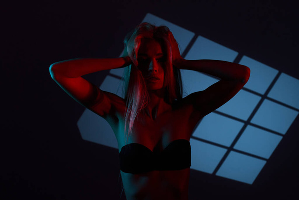 Beautiful girl posing in red light. Unusual photo session with a model. - Foto, Bild