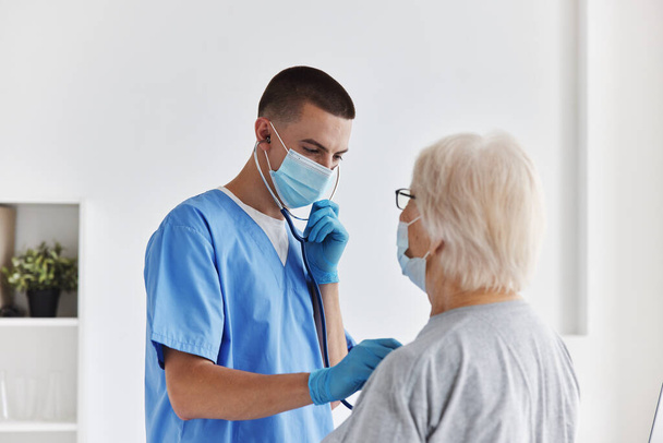 врач-мужчина слушает осмотр пациента - Фото, изображение