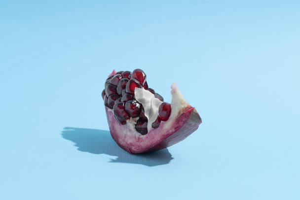 Pomegranate in shape of boat. Blue background. Creative fruit background - Zdjęcie, obraz