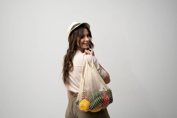 Portrait of young woman with a eco bag of vegetables, greens. Sustainable lifestyle. Eco friendly concept. - Fotó, kép