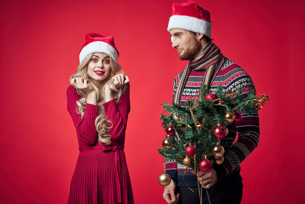 эмоциональный мужчина и женщина рождественские подарки праздник красный фон - Фото, изображение
