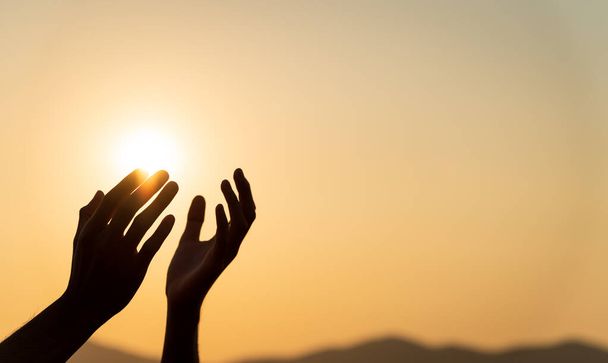 Κοντινό πλάνο γυναίκα χέρια προσεύχεται για ευλογία από τον Θεό κατά τη διάρκεια ηλιοβασίλεμα φόντο. Ελπίδα και ελευθερία. - Φωτογραφία, εικόνα