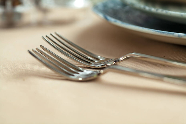 Silver cutlery on table top with tablecloth - Фото, зображення
