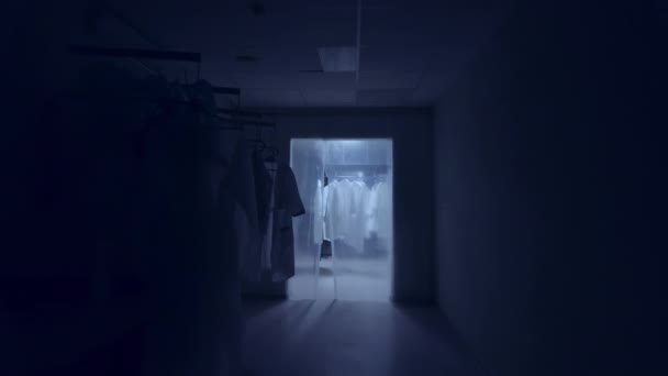 Quarantainezone in de kliniek met medische kledij aan hangers, gesloten ruimte, camerabeweging - Video