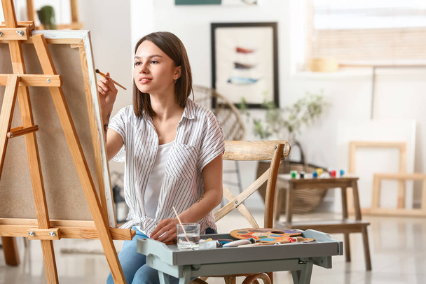 Jonge vrouwelijke kunstenaar schilderen in workshop - Foto, afbeelding