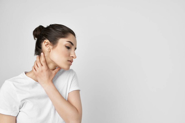 Nainen valkoisessa t-paidassa kipu kaulassa terveysongelmia - Valokuva, kuva